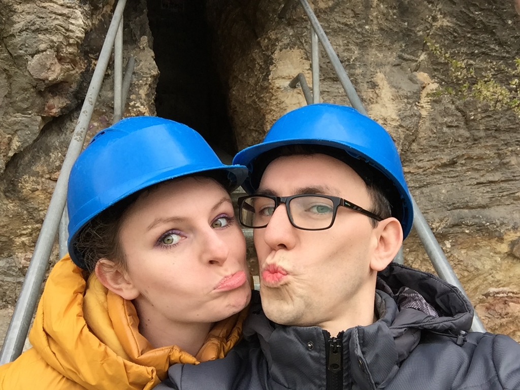 Młoda dziewczyna i chłopak w kaskach na głowie, tuż przed wejściem do atrakcji Jaskinia Kadzielnia.