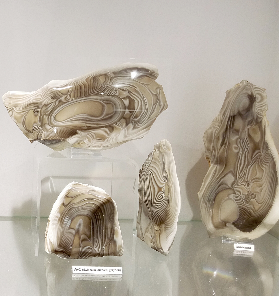 Cztery oszlifowane bryłki krzemienia pasiastego w Galerii Tajemnice Klejnotów w Świętokrzyskim Parku Narodowym.