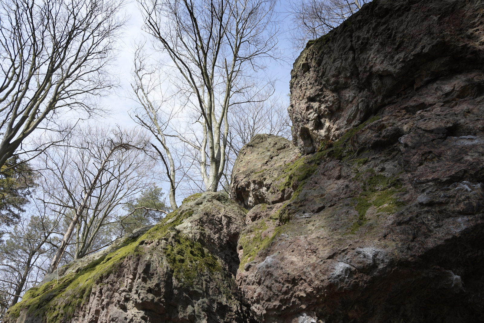 Potężny głaz widziany od dołu, z widokiem na niebo w Kamień Michniowski.