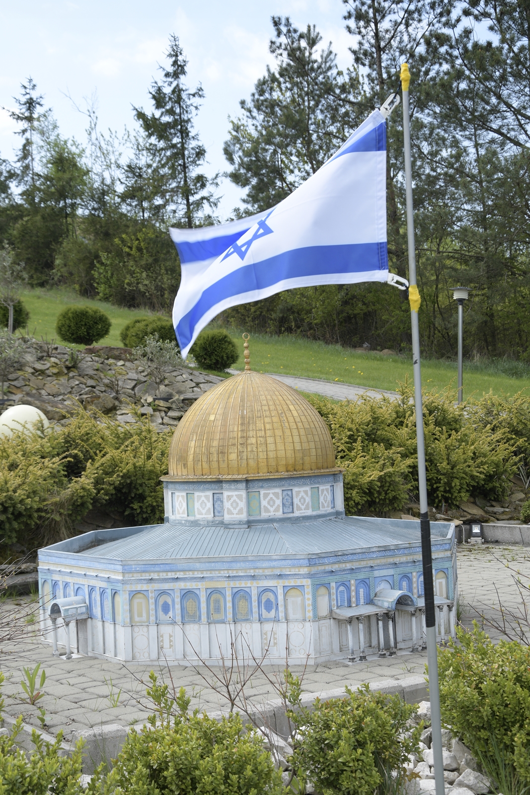 Miniatura bazyliki z Izraela, z wbita nieopodal flagą tego kraju.