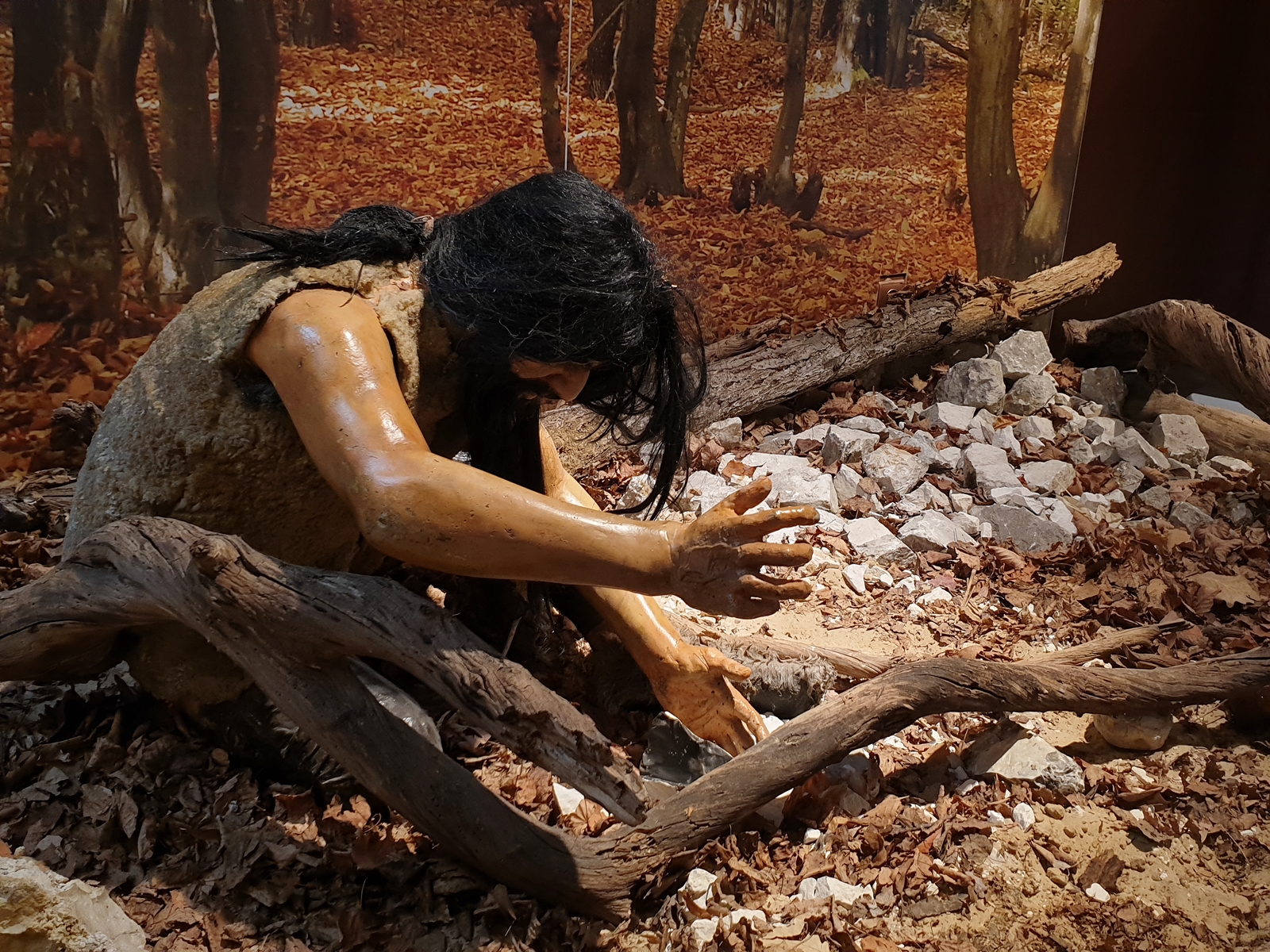 Model dawnego mieszkańca w skórze, sięgającego po kawałek drewna, fragment wystawy w Krzemionkach Opatowskich.