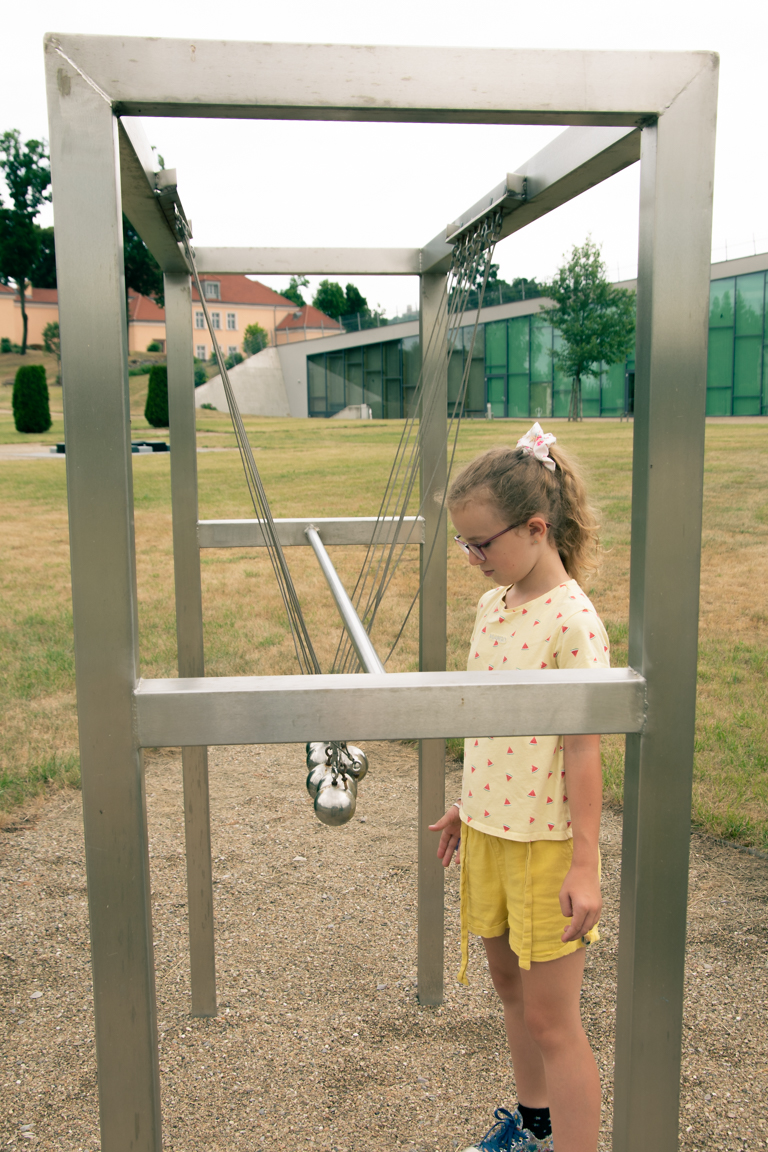 Dziewczynka patrząca na kulki, będące częścią parku doświadczeń w Podzamczu Chęcińskim.