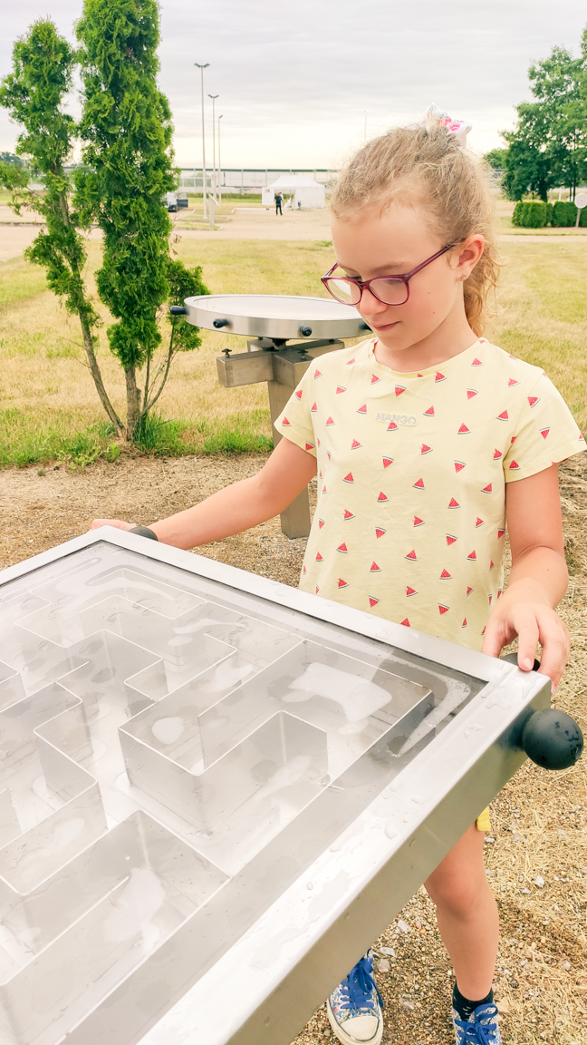 Dziewczynka bawiąca się "labiryntem" w zewnętrznym parku doświadczeń w Podzamczu Chęcińskim.