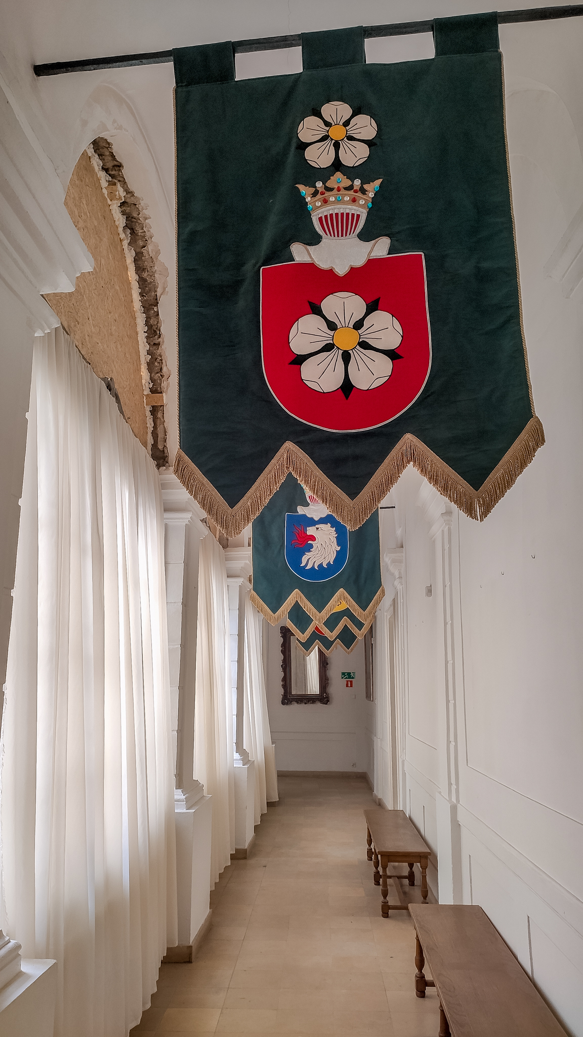 Herby rodziny uwieszone na wąskim korytarzu Pałacu w Kurozwękach.