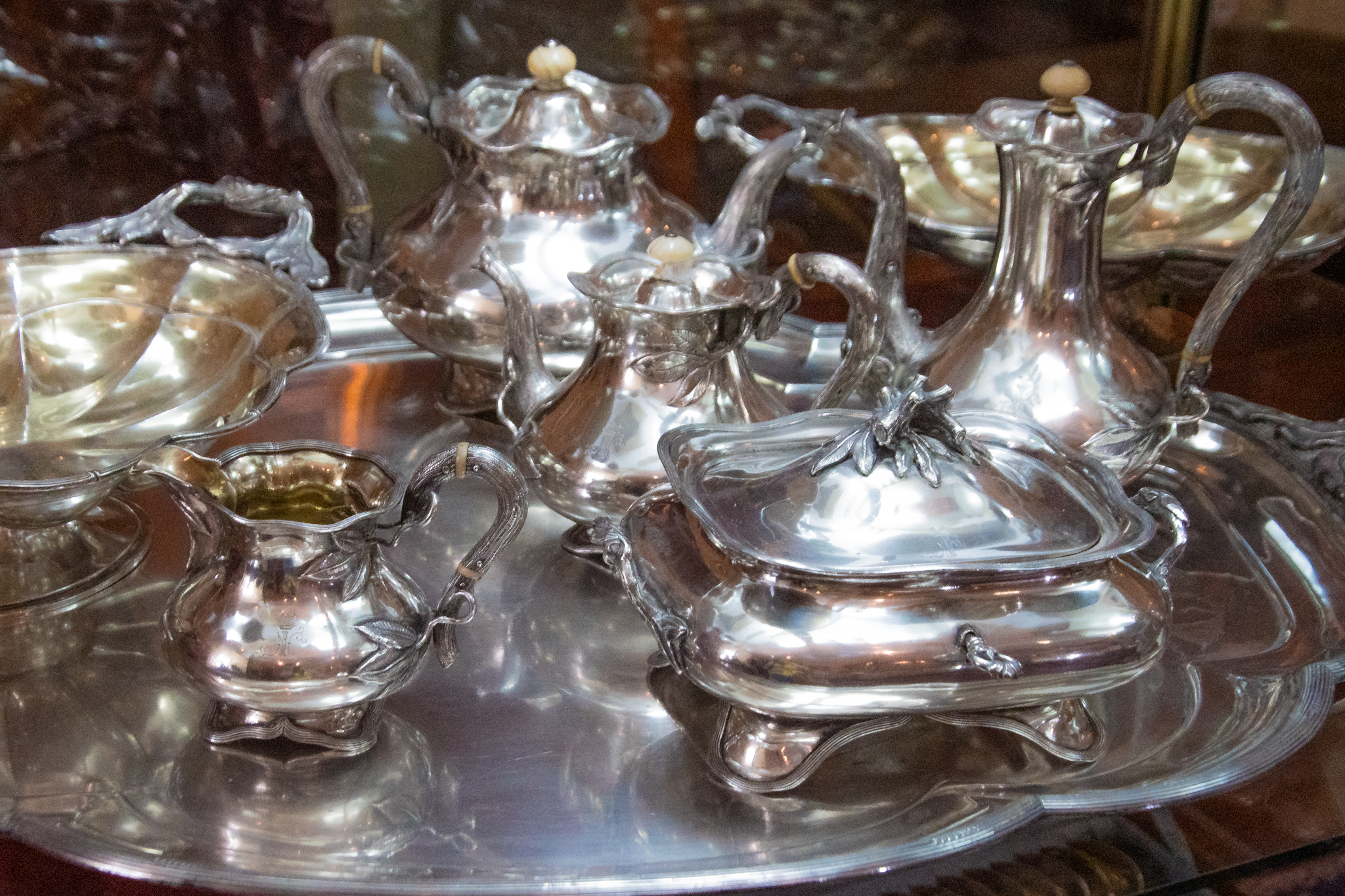 Srebrne naczynia ułożone na srebrnej tacy na wystawie w Kurozwękach.