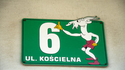 Oznaczenie numeru domu "Kościelna 6" z wymalowanym Koziołkiem Matołkiem.