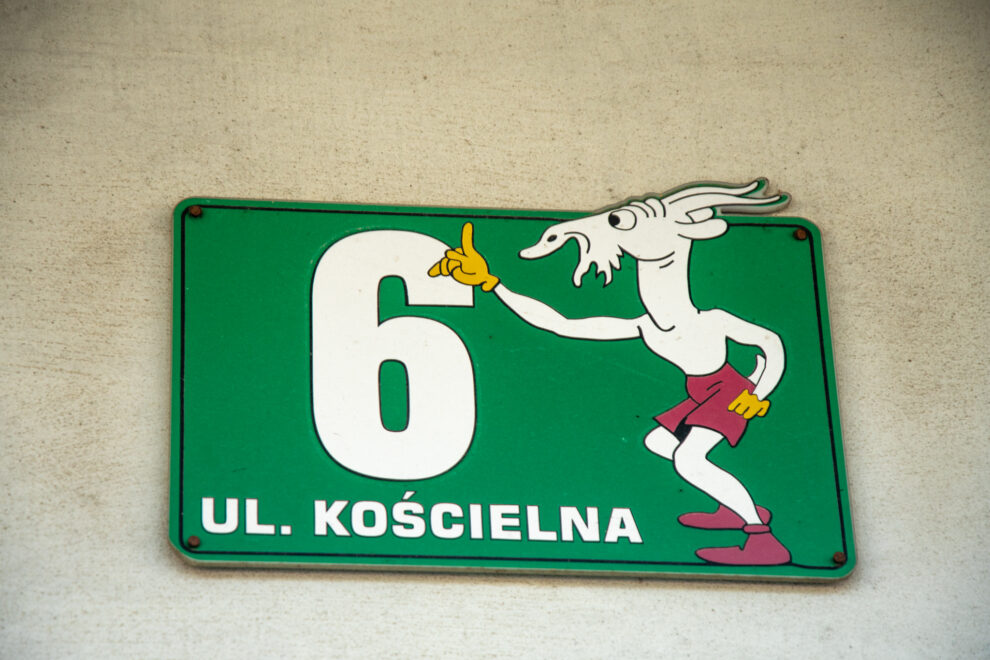 Oznaczenie numeru domu "Kościelna 6" z wymalowanym Koziołkiem Matołkiem.
