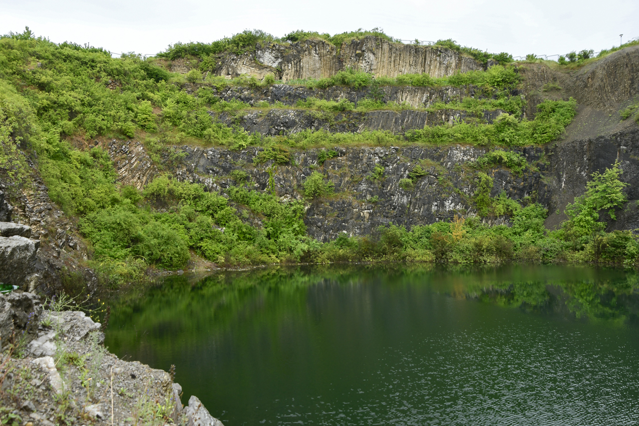 Kamieniołom w Ślichowicach z widocznymi fałdowaniami skał, z przodu widoczny wodny akwen.
