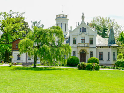 Muzeum Henryka Sienkiewicza w Oblęgorku widziane od zewnątrz, z widokiem na trawę.