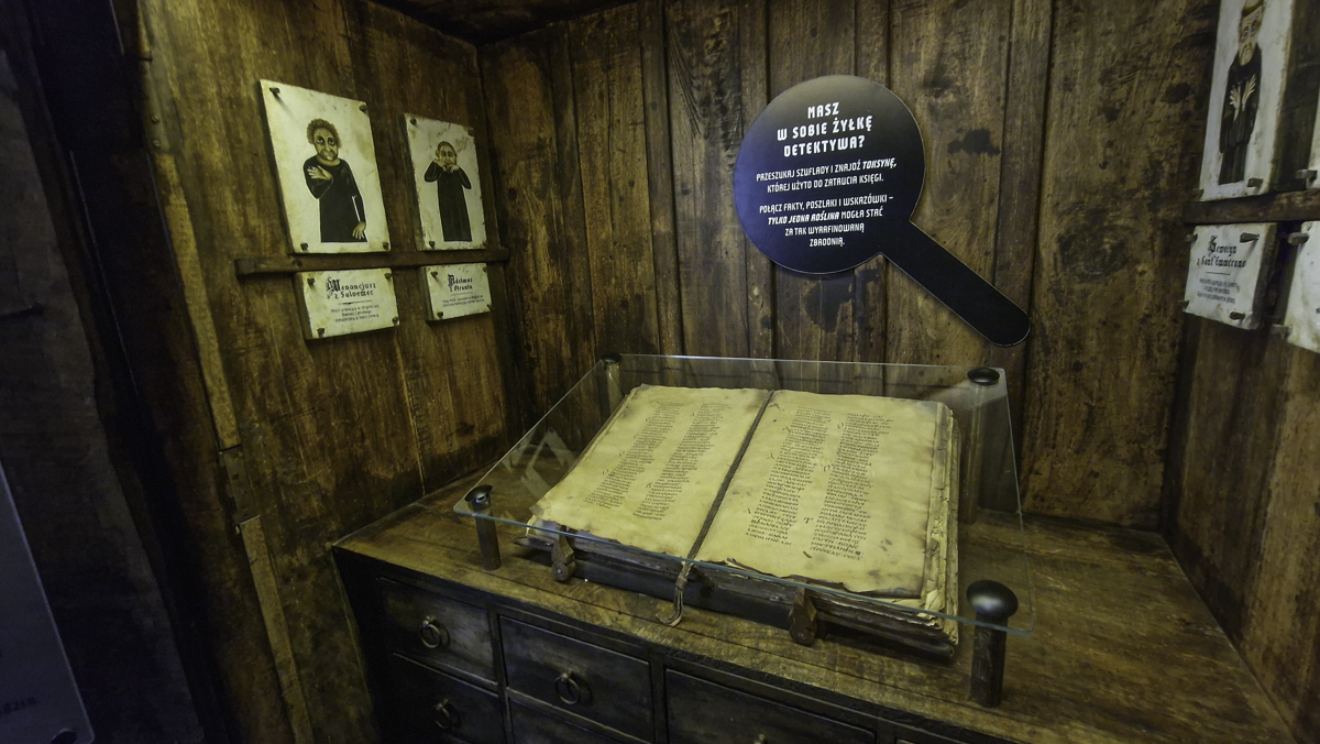 Księga znajdująca się pod szybką, obok napis: "Masz w sobie żyłkę detektywa?" Część wystawy w Muzeum Czary Napary.
