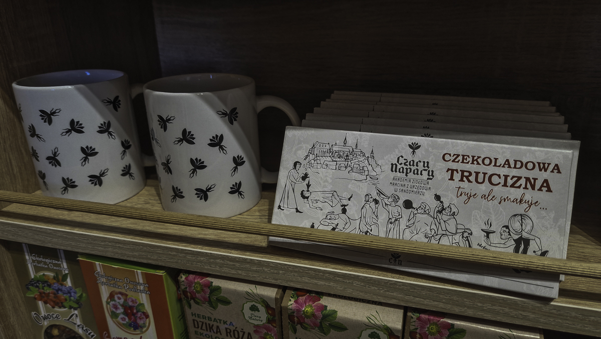 Czekolada sprzedawana w sklepie Czary Napary, sugerująca że w środku jest "czekoladowa trucizna", obok kubek w print z mandragorami.